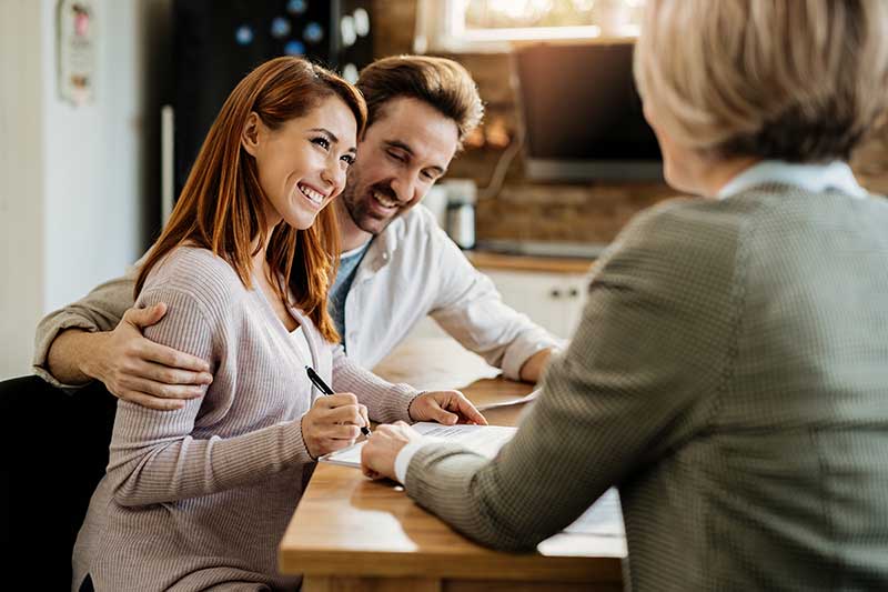 young-happy-woman-her-husband-signing-agreement-with-insurance-agent-meeting